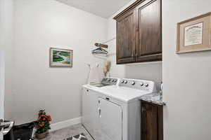 Washroom with cabinets and washer and dryer