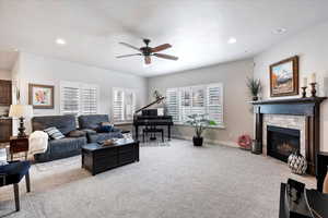 Carpeted living room featuring a textured ceiling and ceiling fan