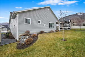 View of side of home featuring a mountain view and a lawn