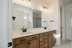 Bathroom featuring an enclosed shower, vanity, tile patterned floors, and toilet