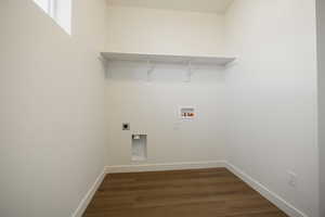 Clothes washing area featuring dark wood-type flooring, hookup for a washing machine, and electric dryer hookup