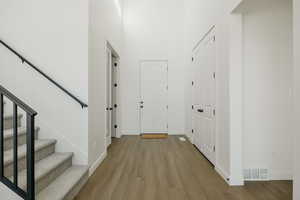 Hall featuring a high ceiling and light hardwood / wood-style flooring