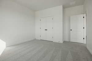 Unfurnished bedroom featuring light colored carpet and a closet