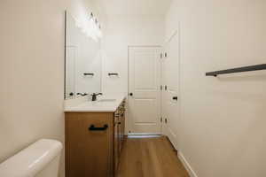 Bathroom featuring vanity, hardwood / wood-style flooring, and toilet