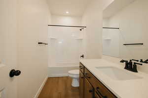 Full bathroom with vanity, hardwood / wood-style floors, bathtub / shower combination, and toilet