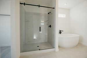 Bathroom featuring separate shower and tub and tile patterned floors