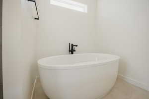 Bathroom featuring tile patterned flooring and a washtub