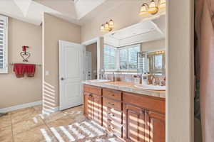 Bathroom with vanity, tile patterned flooring, and a shower with door