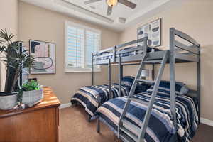 Bedroom with a tray ceiling and carpet floors