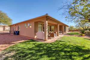 Back of property with a patio area and a lawn