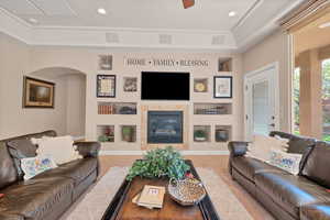 Carpeted living room featuring built in shelves and a tile fireplace