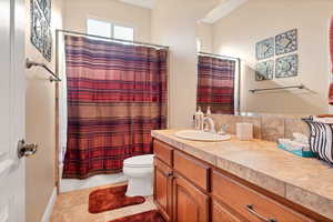 Bathroom featuring vanity, tile patterned floors, and toilet