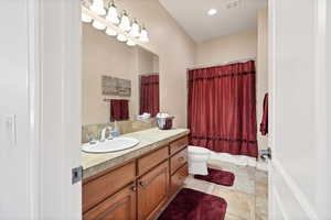 Bathroom with tile patterned floors, vanity, and toilet