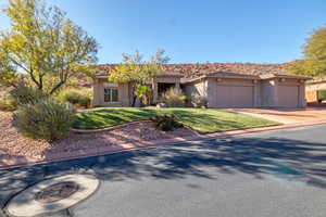 View of front of property featuring a garage and a front lawn