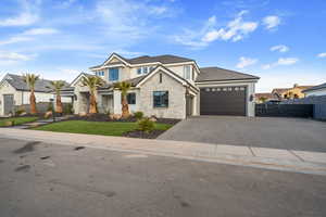 View of front of house with a garage and a front lawn