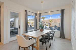 Dining room featuring light parquet flooring, a mountain view, and a notable chandelier