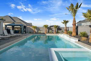 View of pool featuring area for grilling and a gazebo