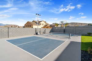 View of sport court with a mountain view and basketball hoop