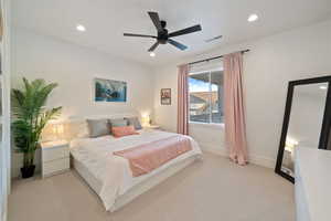 Bedroom with ceiling fan and light colored carpet