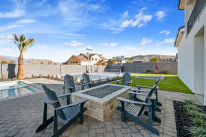 View of patio with a mountain view, a fenced in pool, and an outdoor fire pit