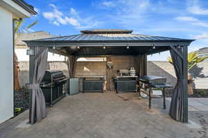 View of patio featuring a gazebo, grilling area, and exterior kitchen