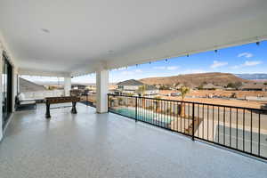 View of patio with a fenced in pool, a balcony, and a mountain view