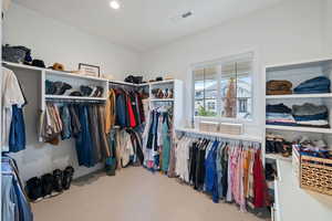 Walk in closet with light colored carpet