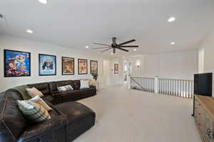 Living room with light colored carpet and ceiling fan