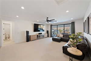 Carpeted living room featuring ceiling fan