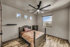 Bedroom featuring ceiling fan, light hardwood / wood-style flooring, and a textured ceiling