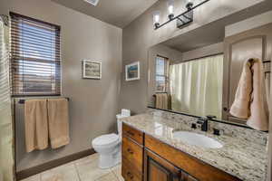 Bathroom featuring tile patterned flooring, vanity, and toilet