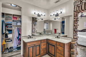 Bathroom featuring hardwood / wood-style flooring, ceiling fan, vanity, and a textured ceiling