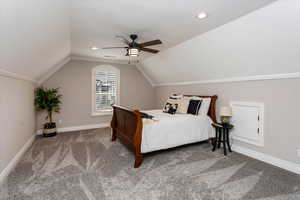 Carpeted bedroom with vaulted ceiling and ceiling fan