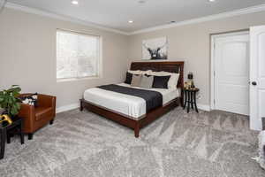 Bedroom with crown molding and carpet