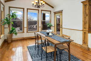 Dining space featuring vaulted ceiling, a chandelier, and light hardwood / wood-style floors