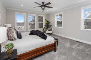 Bedroom featuring crown molding, ceiling fan, carpet floors, and multiple windows