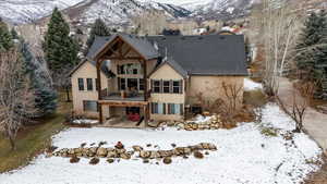 Snow covered back of property featuring a mountain view