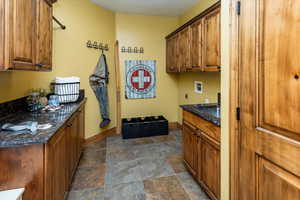 Interior space featuring washer hookup, electric dryer hookup, sink, and cabinets