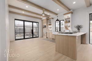 Kitchen featuring sink, decorative light fixtures, light brown cabinets, kitchen peninsula, and light hardwood / wood-style floors