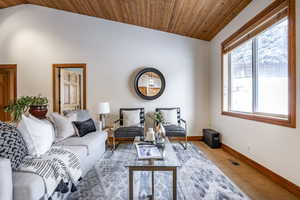 Carpeted living room featuring lofted ceiling and wooden ceiling