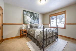 Bedroom featuring light carpet and a textured ceiling