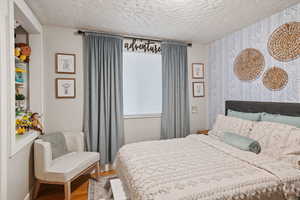 Bedroom featuring wood-type flooring and a textured ceiling