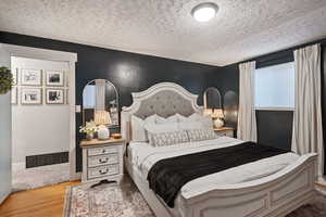 Bedroom with wood-type flooring and a textured ceiling