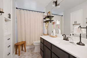 Bathroom with a shower with curtain, vanity, and toilet