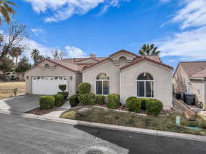 Mediterranean / spanish-style house featuring a garage and central AC unit