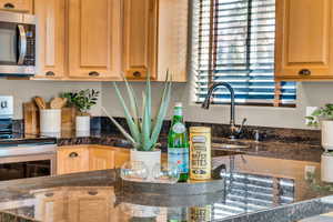 Kitchen featuring dark stone countertops and stainless steel appliances