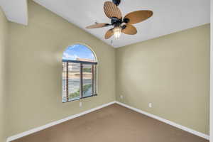 Spare room featuring ceiling fan and carpet floors