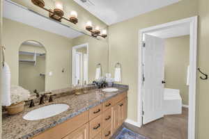 Bathroom featuring tile patterned flooring, vanity, and a textured ceiling