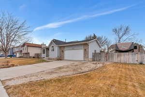 Single story home with a garage and a front lawn, extra parking and RV parking