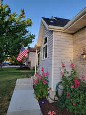 View of home's exterior featuring Hollyhocks during the summer